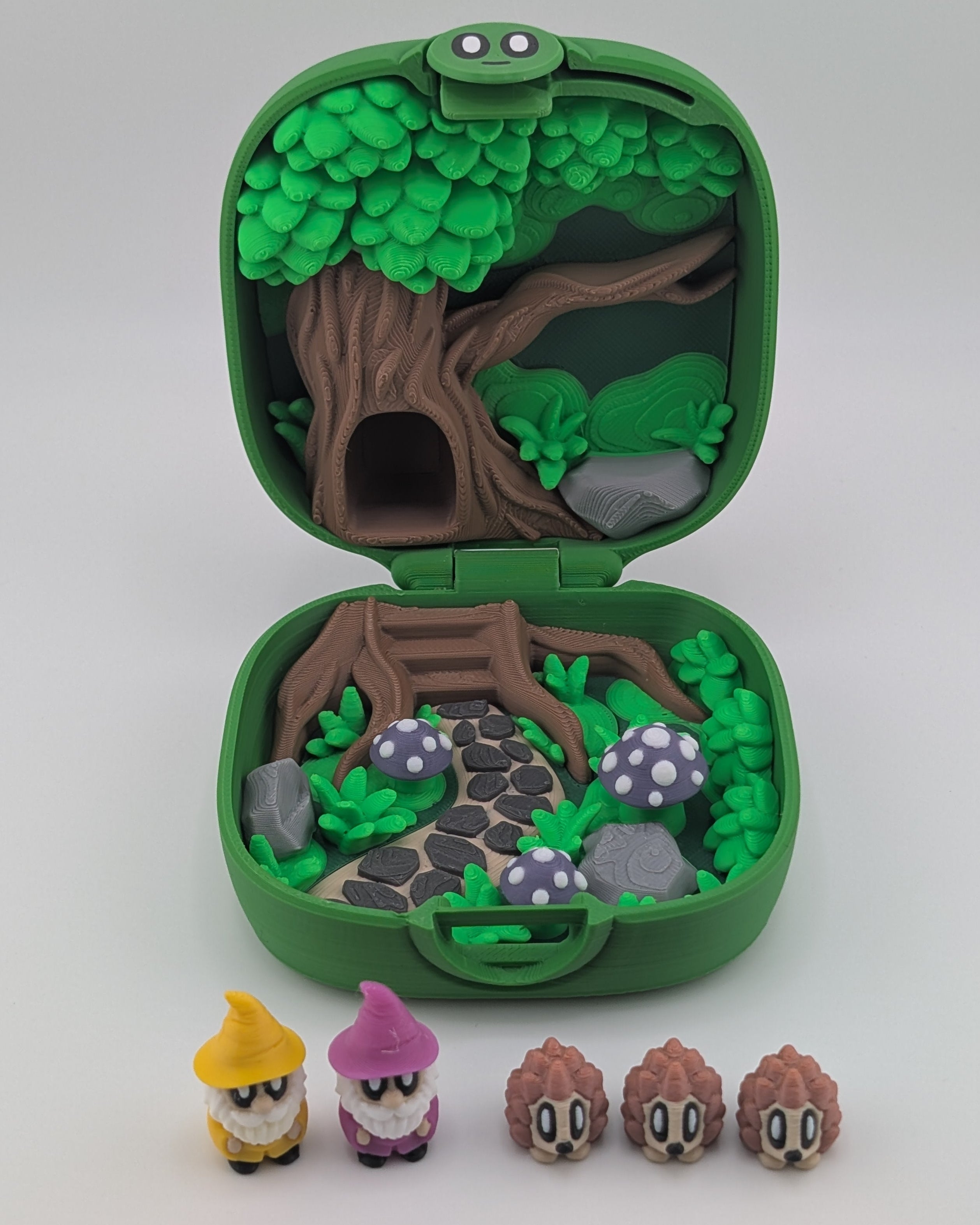 Green toy case with a forest design and small figurines on a white background