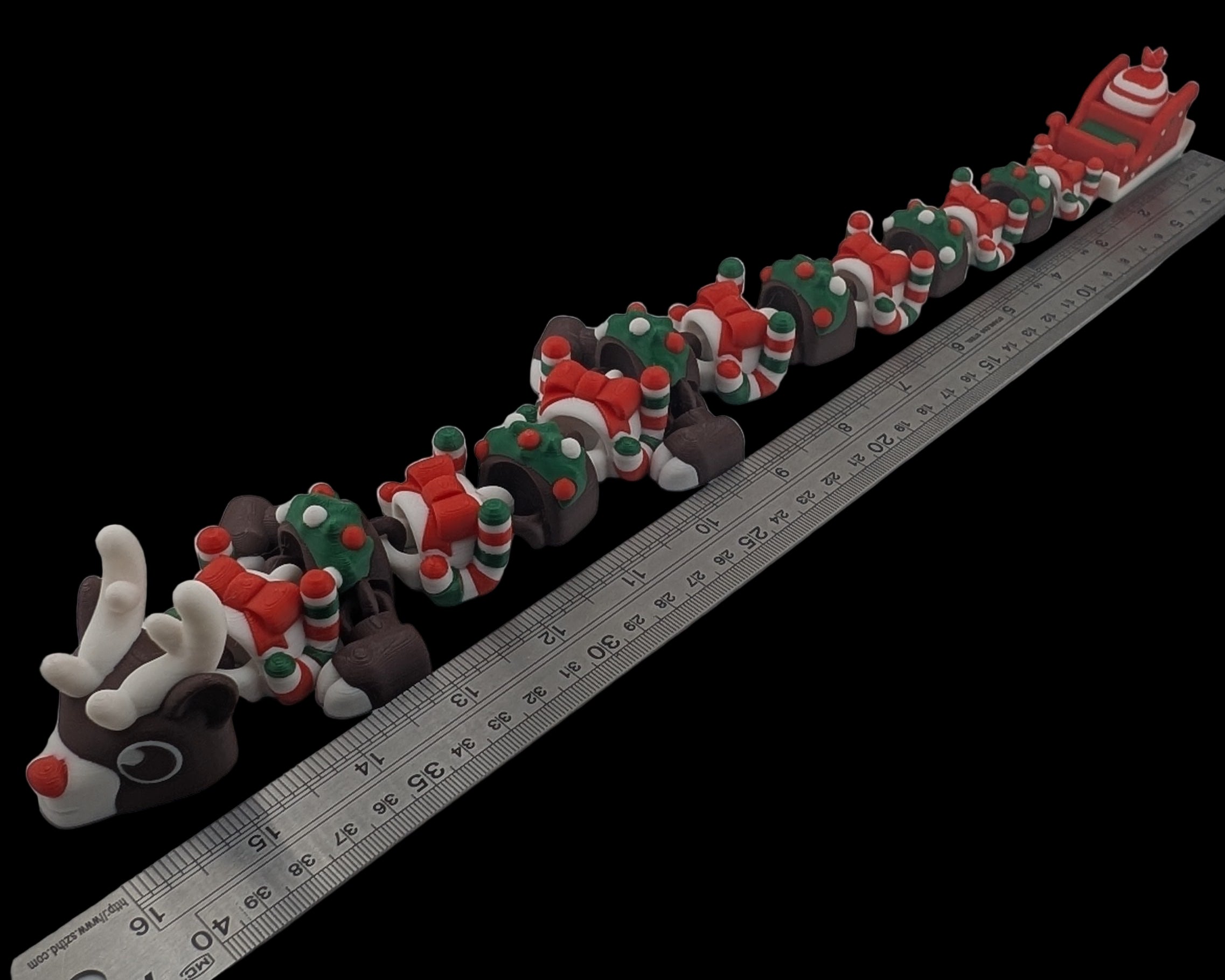 Small figurines arranged on a white surface with a ruler for scale.