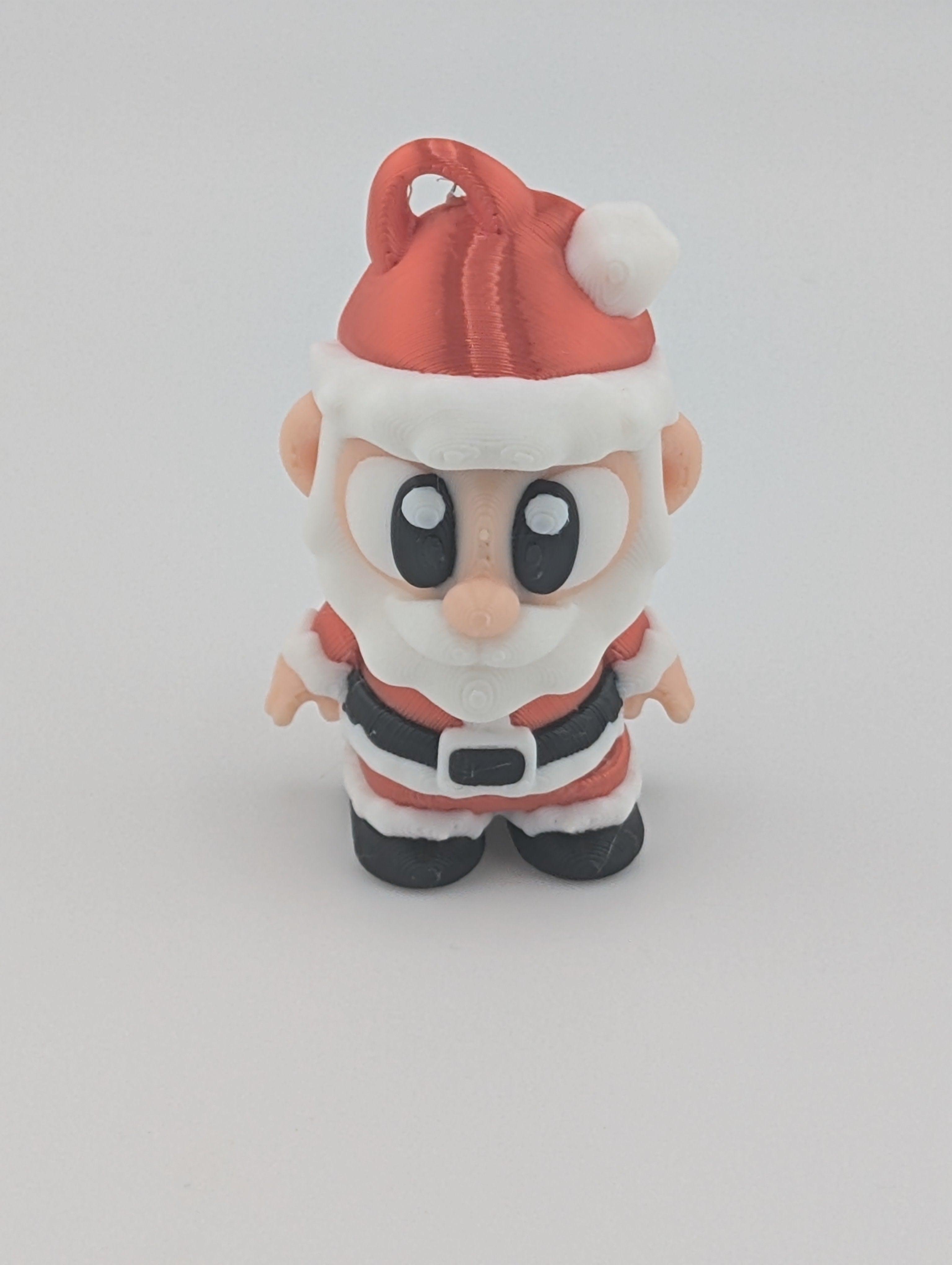Small figurine of a character in a Santa Claus outfit on a white background
