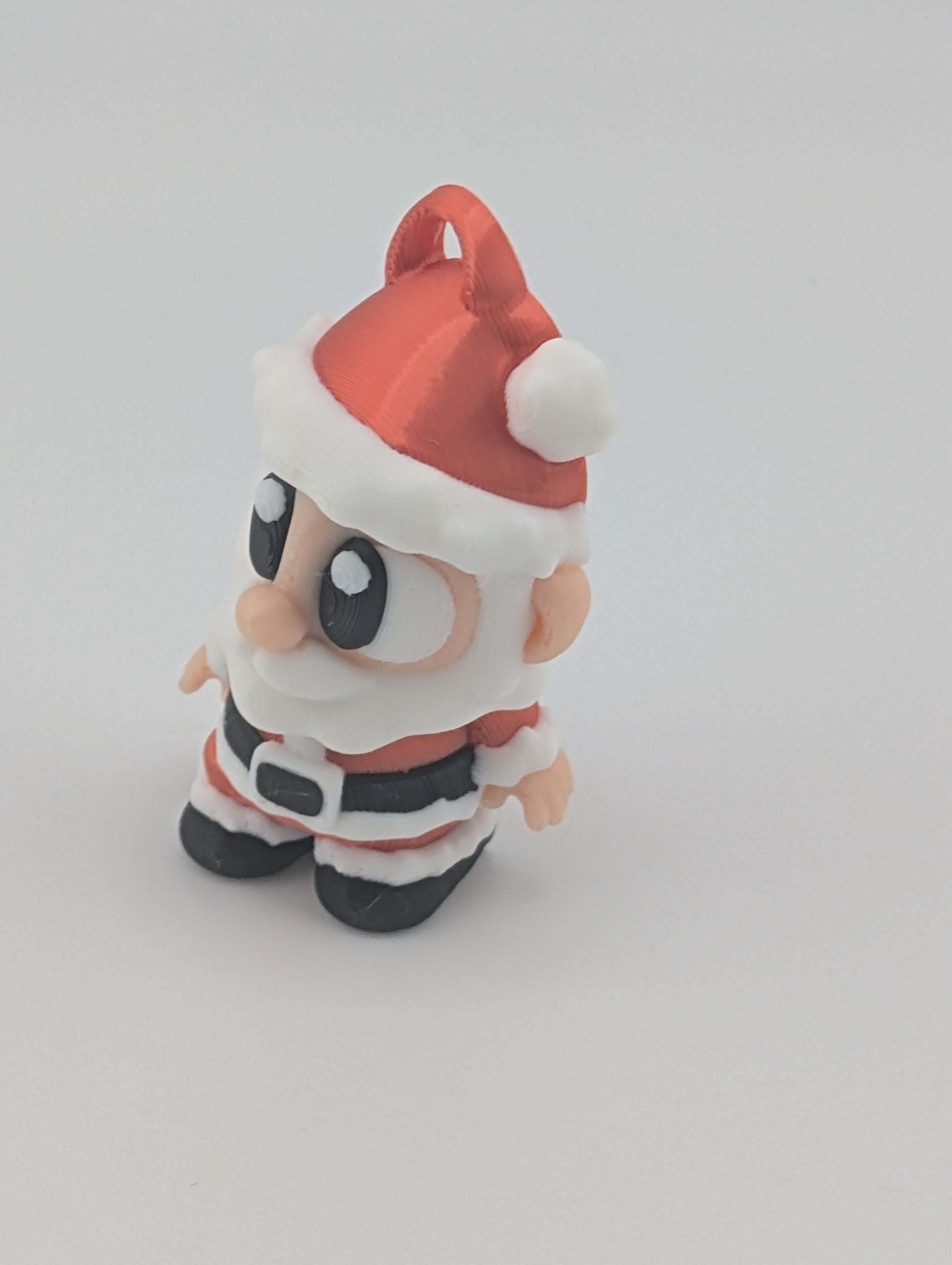 Small figurine of a character wearing a Santa hat on a white background