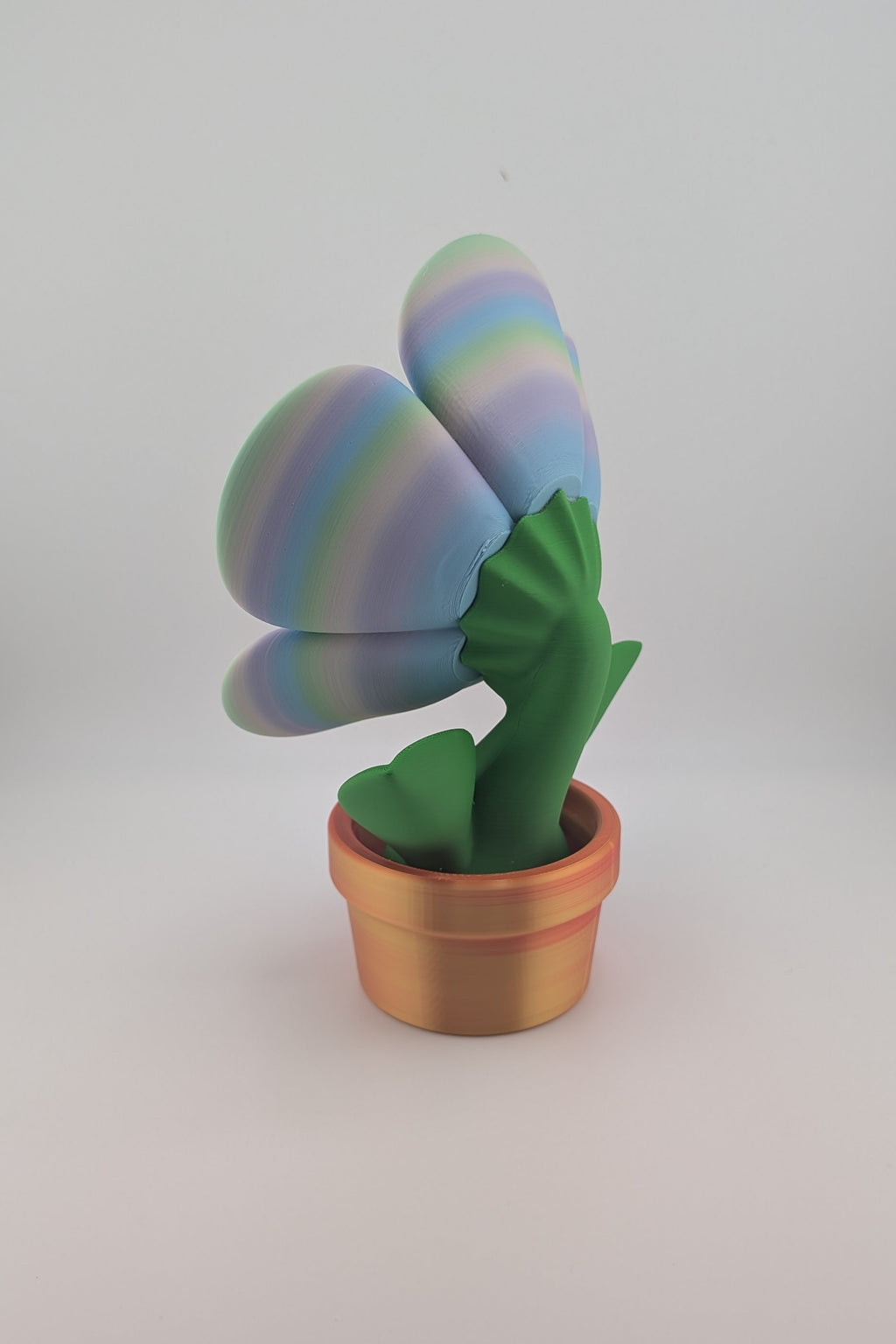 Colorful cactus-shaped toy in a pot on a white background