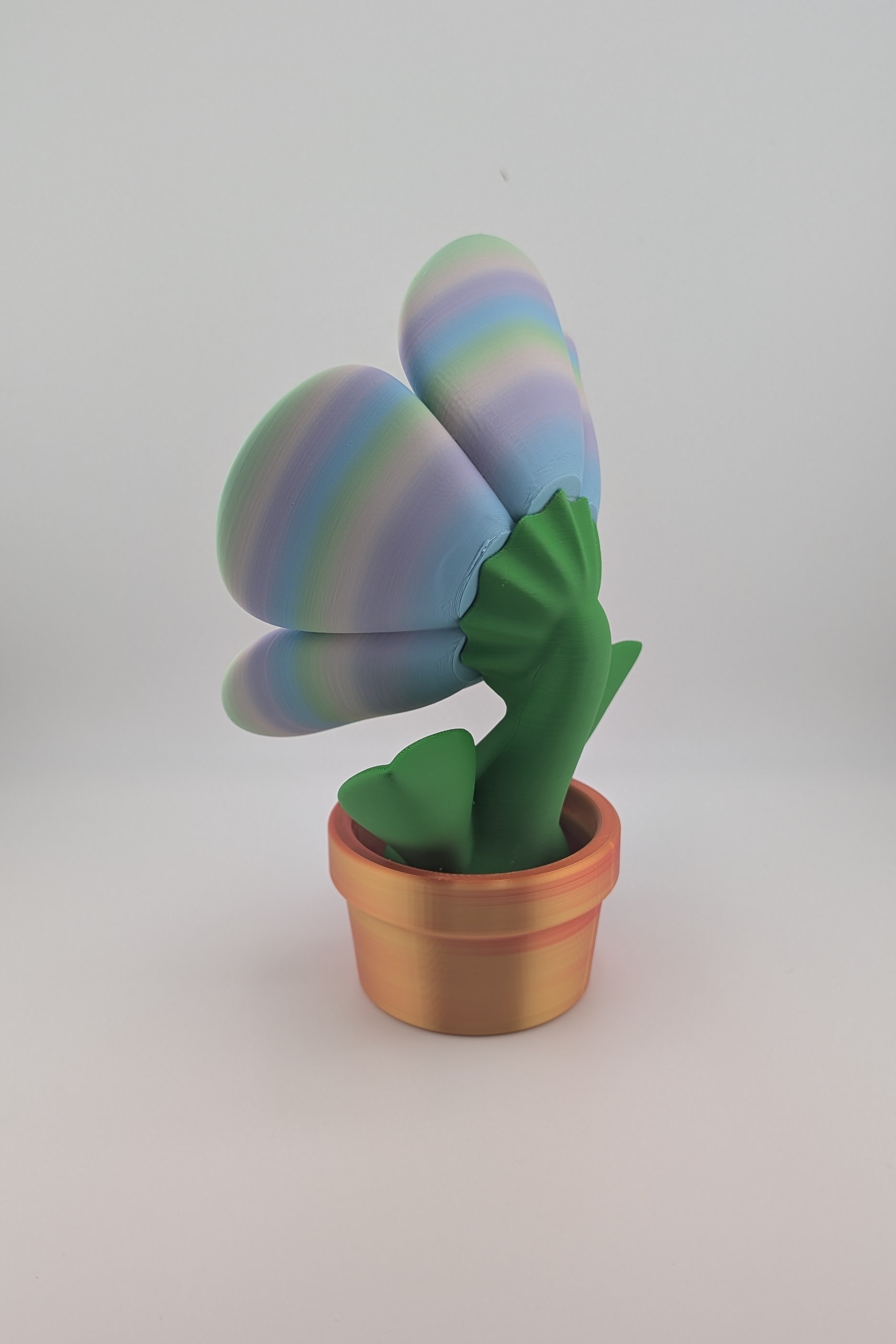 Colorful cactus-shaped toy in a pot on a white background